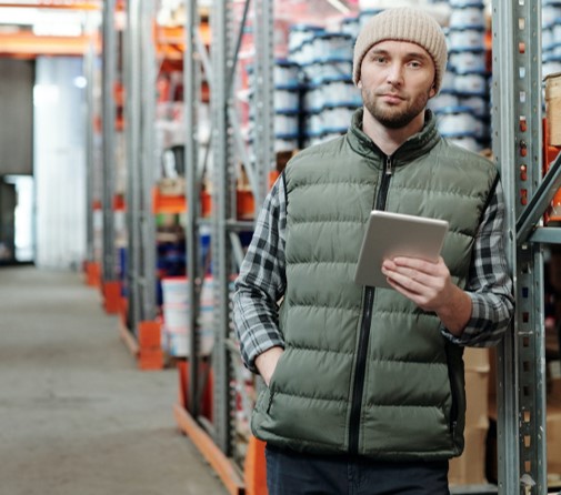 Un technicien utilise une tablette dans l'entrpôt d'une usine